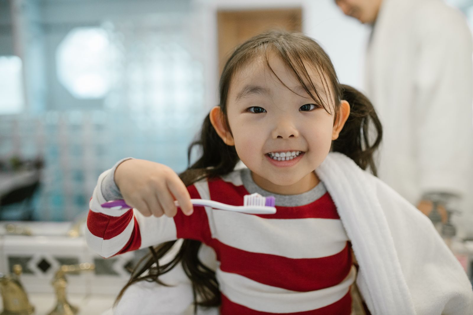 A child brushing their teeth at the bathroom sink