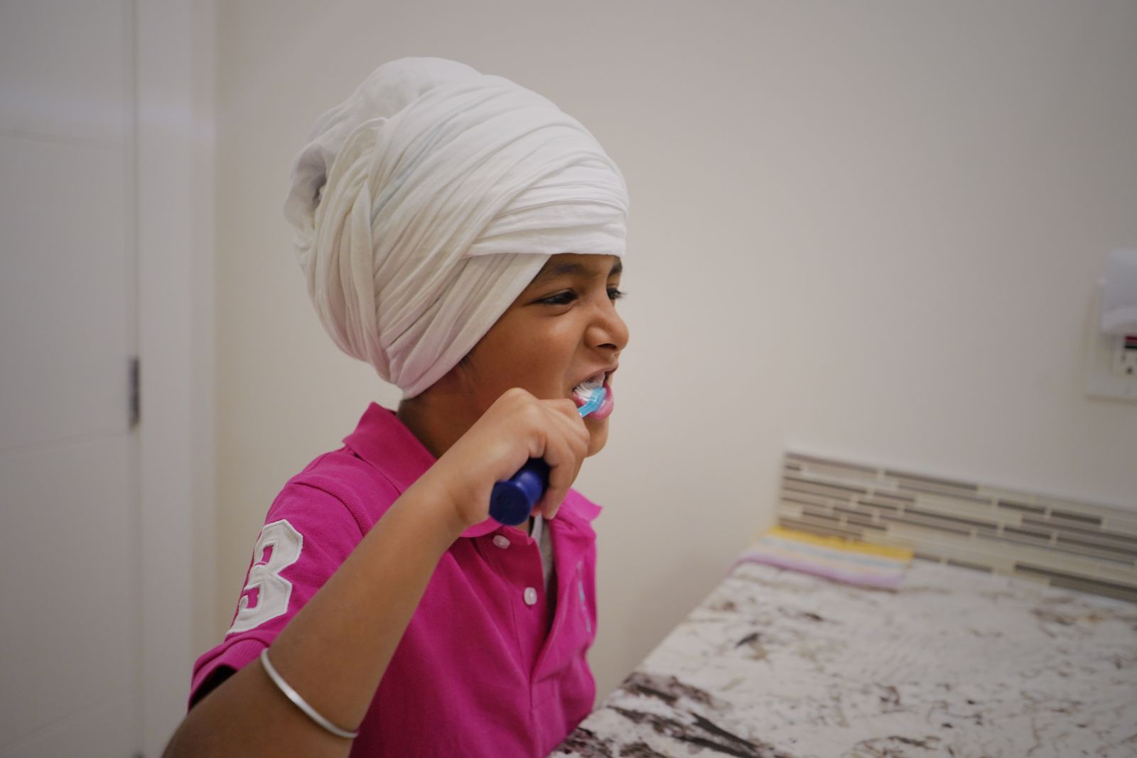 A parent helping a young child brush their teeth