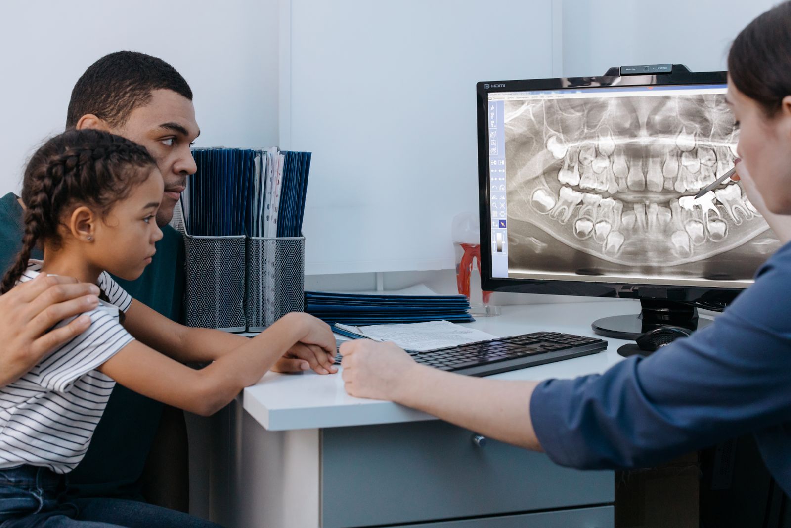 Father and daughter reviewing a dental X-ray with the dentist