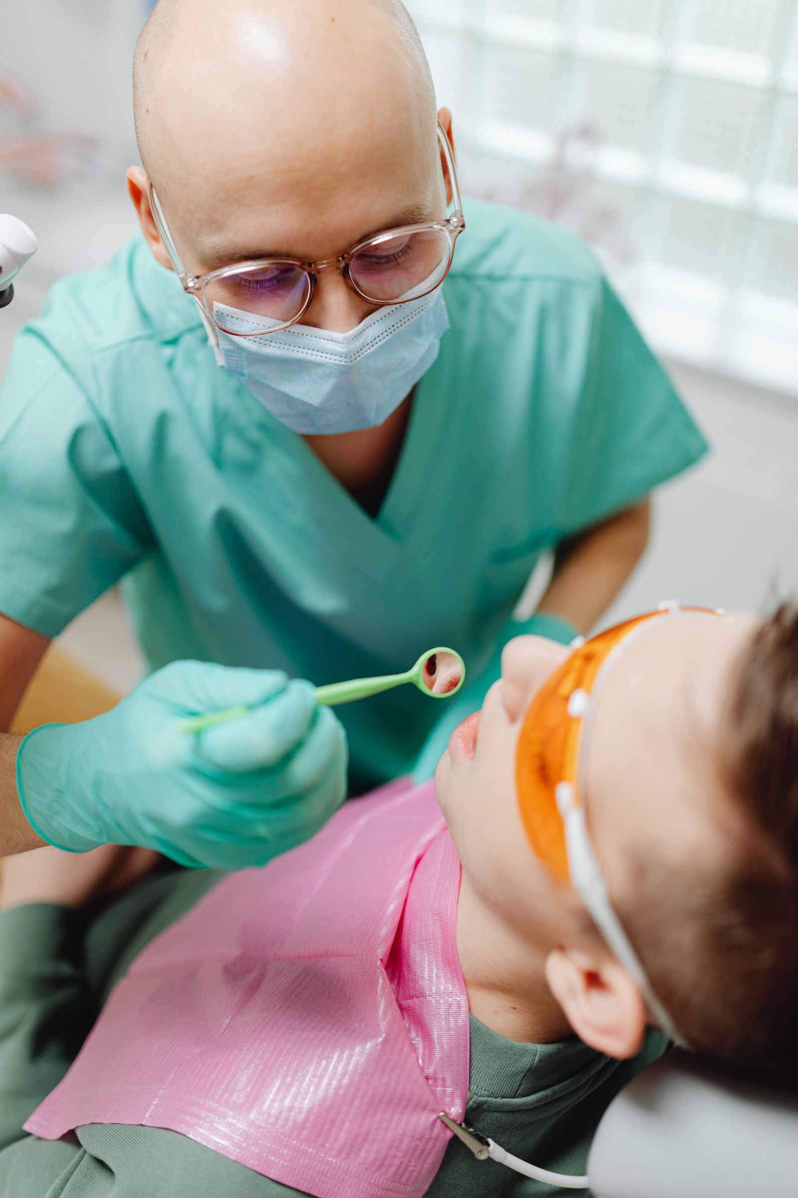 Dentist checking a child's back teeth for sealants