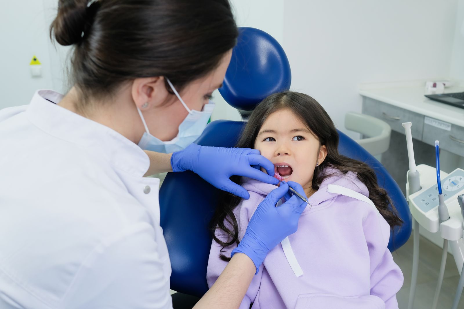 Little girl smiling through a gentle checkup with a pediatric dentist